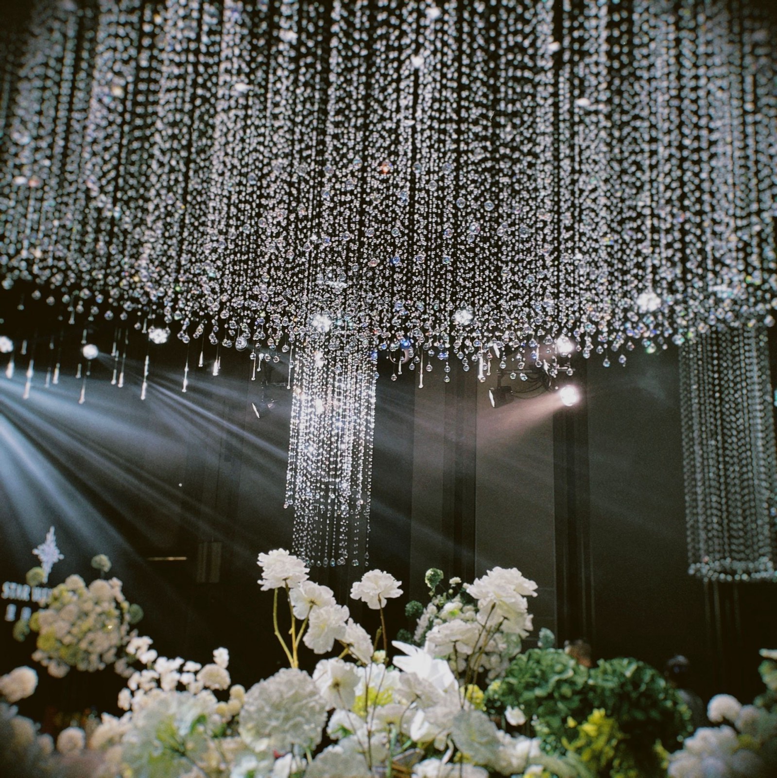 Crystal chandelier and white floral wedding décor